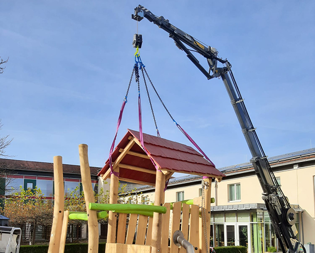 Minikran beim Heben an einem Spielplatz